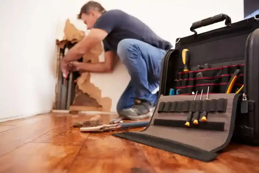 A technician removing wet flooring in a Des Plaines home